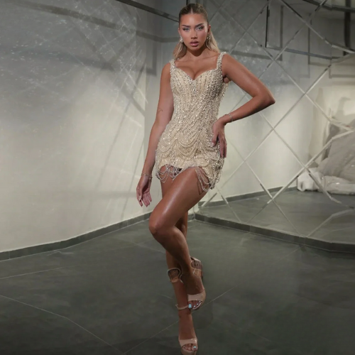 Woman in the sparkling Stardust Mini posing in a modern indoor setting