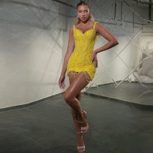 Woman in the sparkling Stardust Mini posing in a modern indoor setting