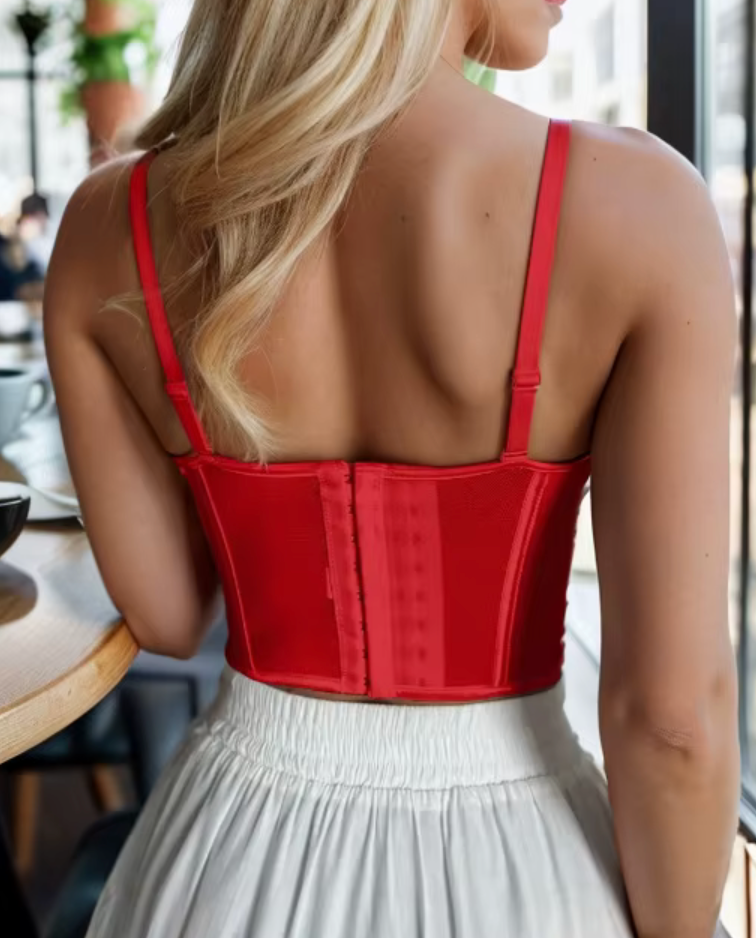 Back view of a vibrant red handmade corset bustier with adjustable straps and a secure hook-and-eye back closure.