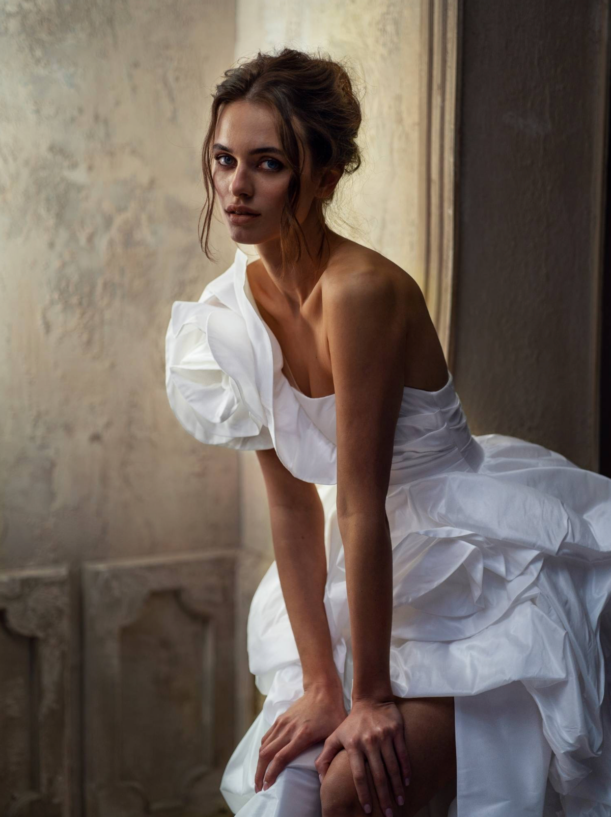 White one-shoulder taffeta ball gown with dimensional floral bodice and high side slit.