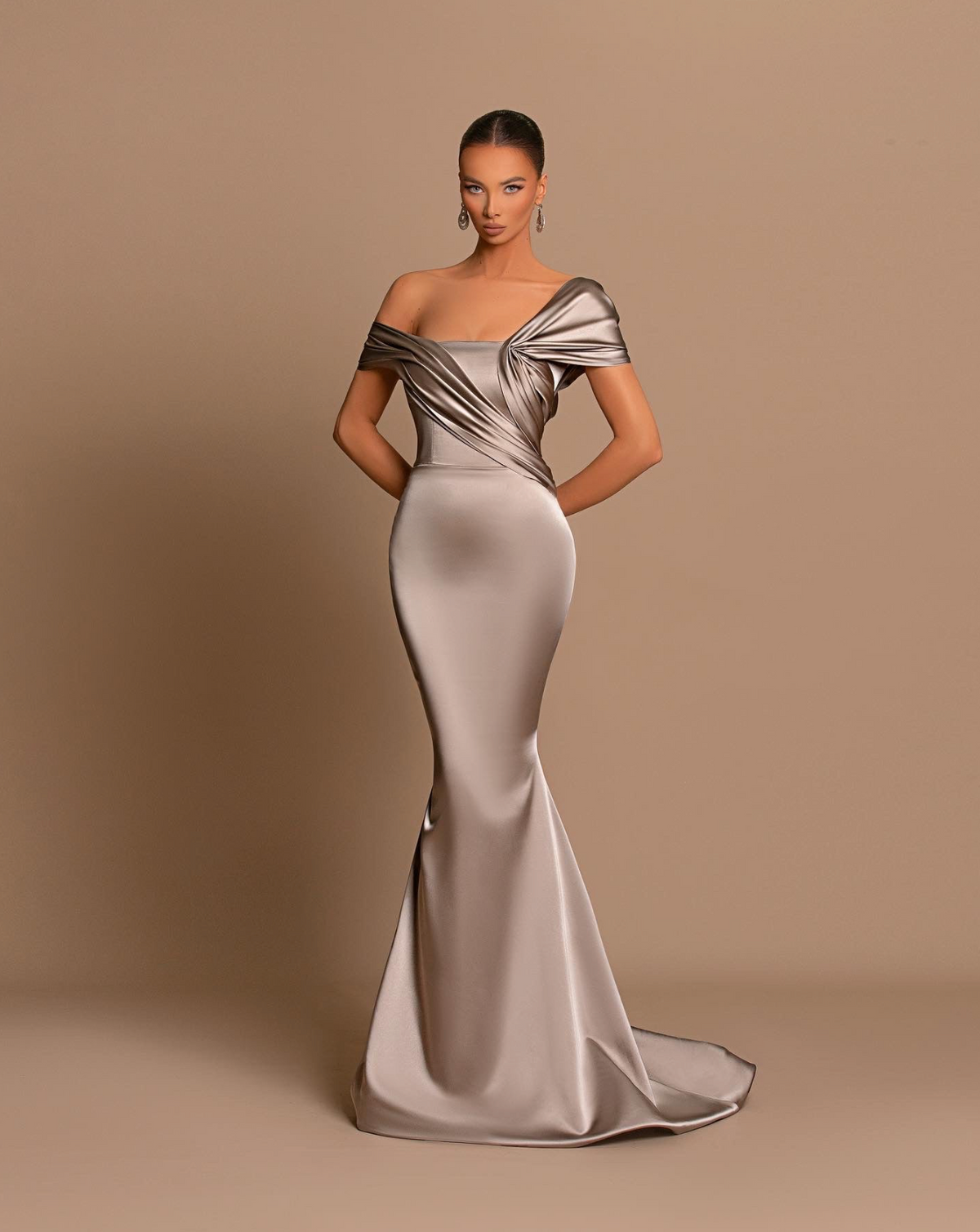 Chrome off-shoulder maxi gown in metallic satin with a structured corset bodice and elegant cascading drape.