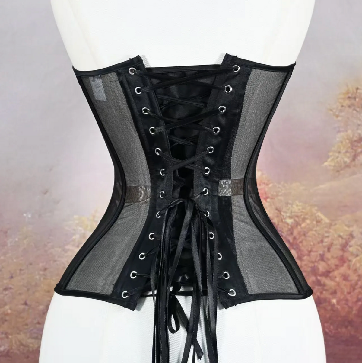 Black handmade mesh corset with structured boning and a lace-up back closure on a mannequin.