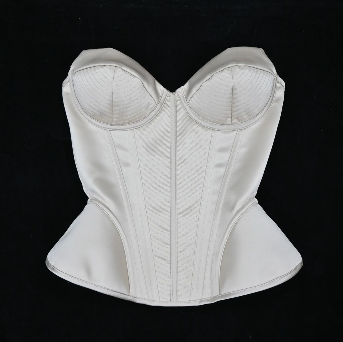 Enni luxury ivory satin corset bustier with structured boning and intricate stitched panel detailing.