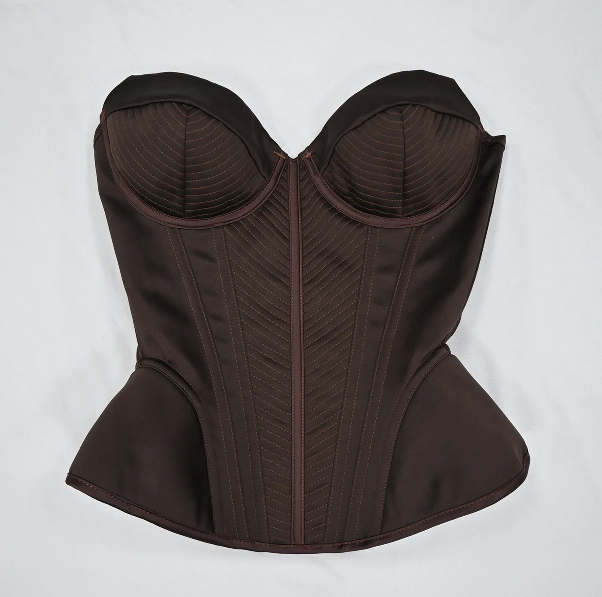 Dark brown structured corset bustier with intricate stitched detailing and a vintage-inspired sculpted silhouette.
