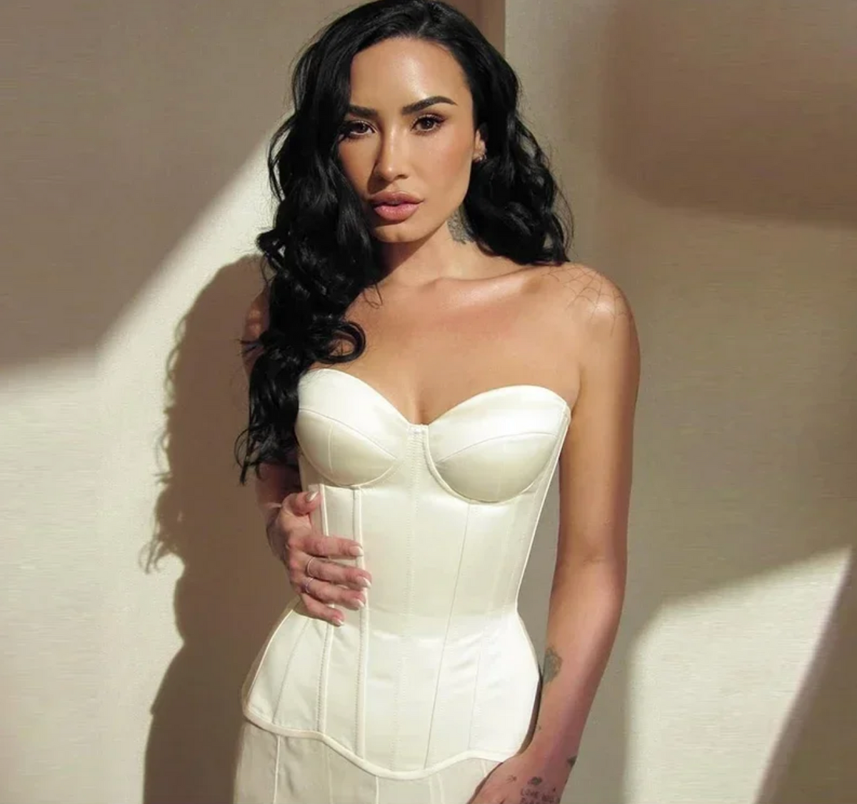 Woman wearing a sleek, strapless white Fynn corset top with a structured, curve-hugging bandage design.