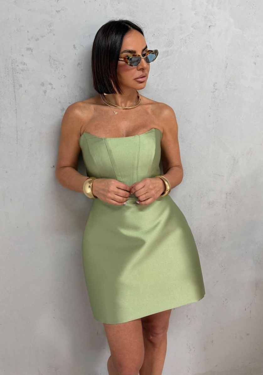 Sage green strapless satin mini dress with a structured architectural bodice and smooth, luminous finish.