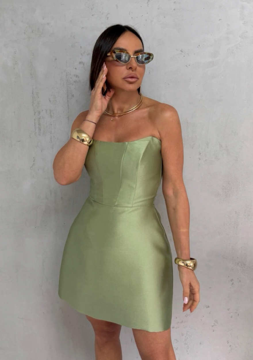 Sage green satin strapless mini dress with architectural seams and a sleek, polished silhouette.