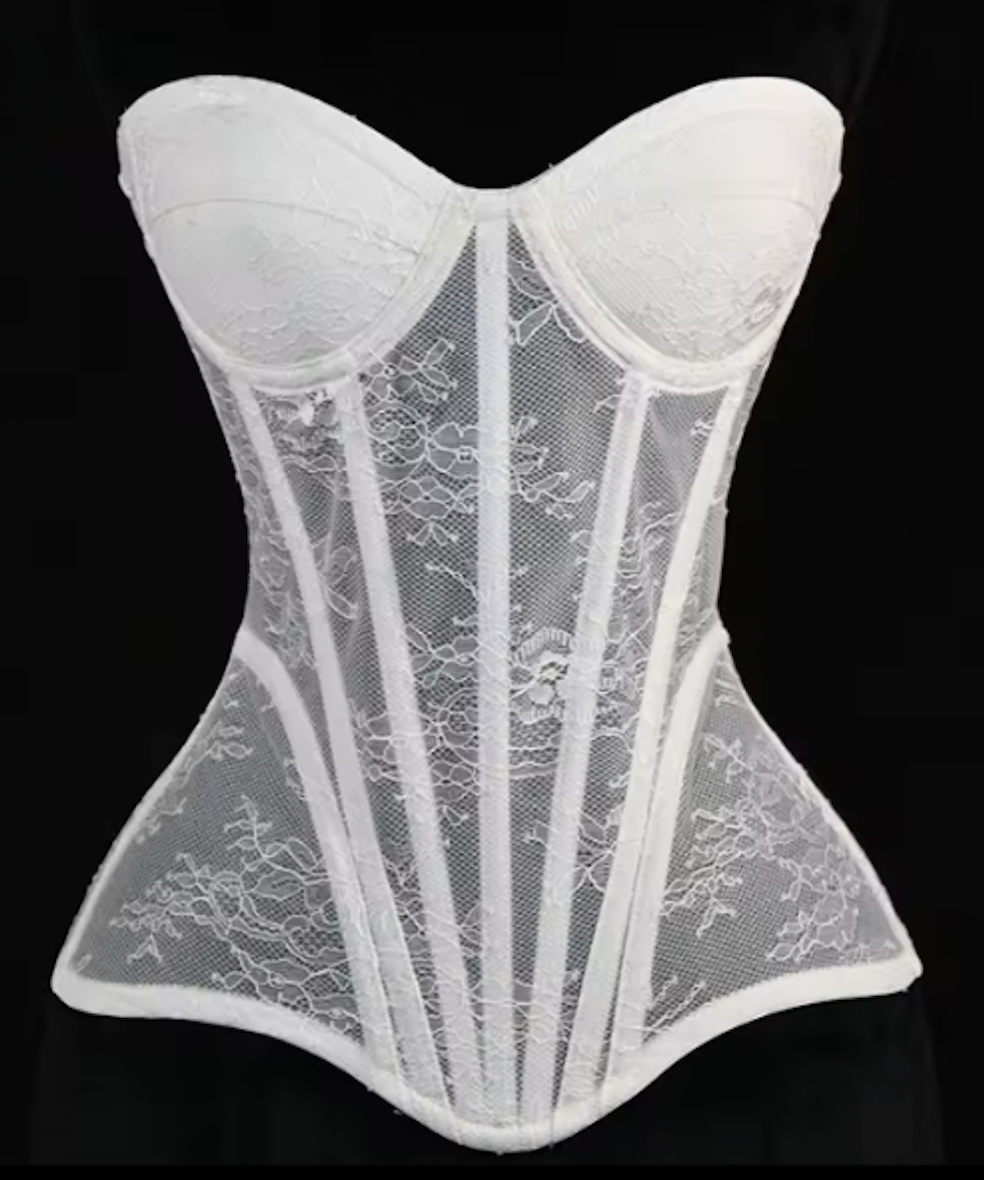 White Gia corset bustier featuring intricate lace detailing, steel-boned construction, and a sculpted waist silhouette.