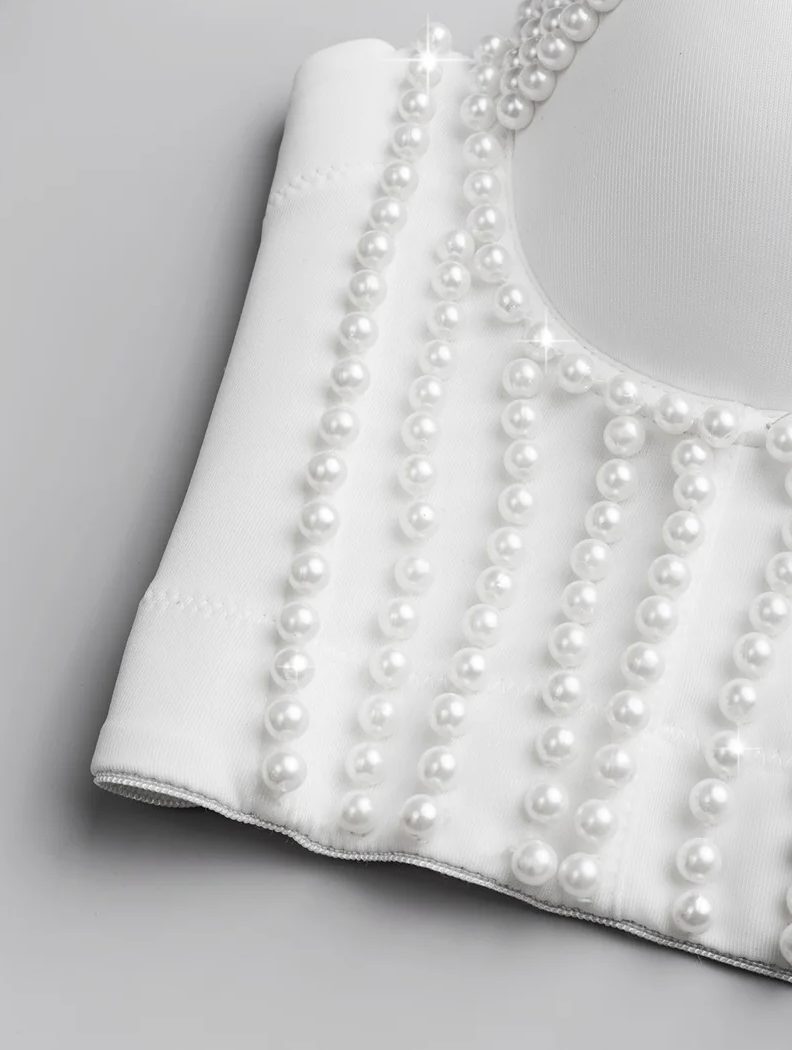 White handmade corset camisole featuring elegant vertical pearl bead embellishments on smooth polyester fabric.