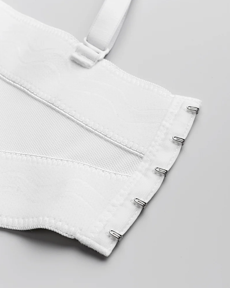 White handmade corset back with metal hook-and-eye closures, mesh panels, and adjustable strap detail.