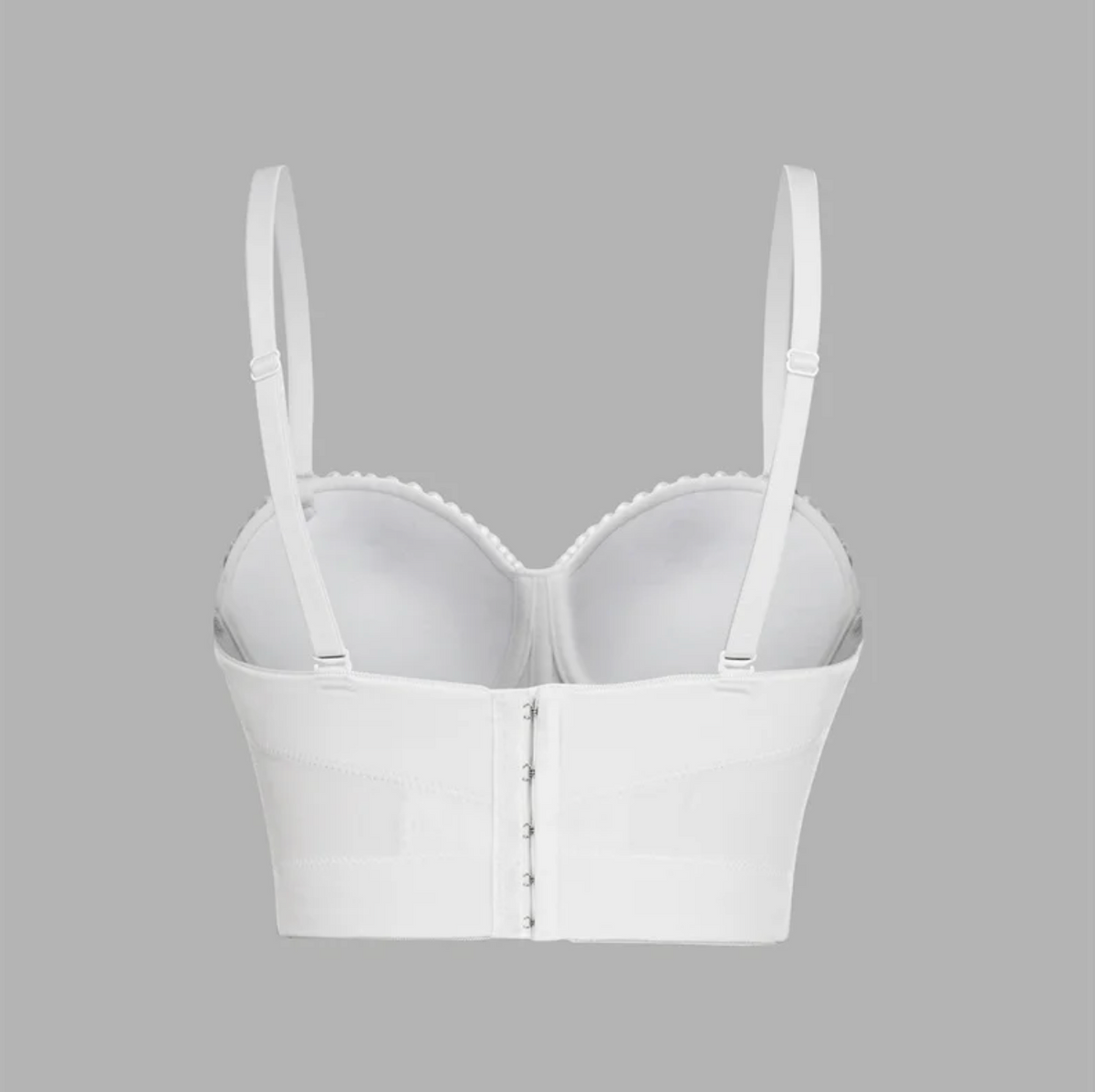 White handmade corset camisole with adjustable straps, hook-and-eye back closure, and structured, fitted silhouette.