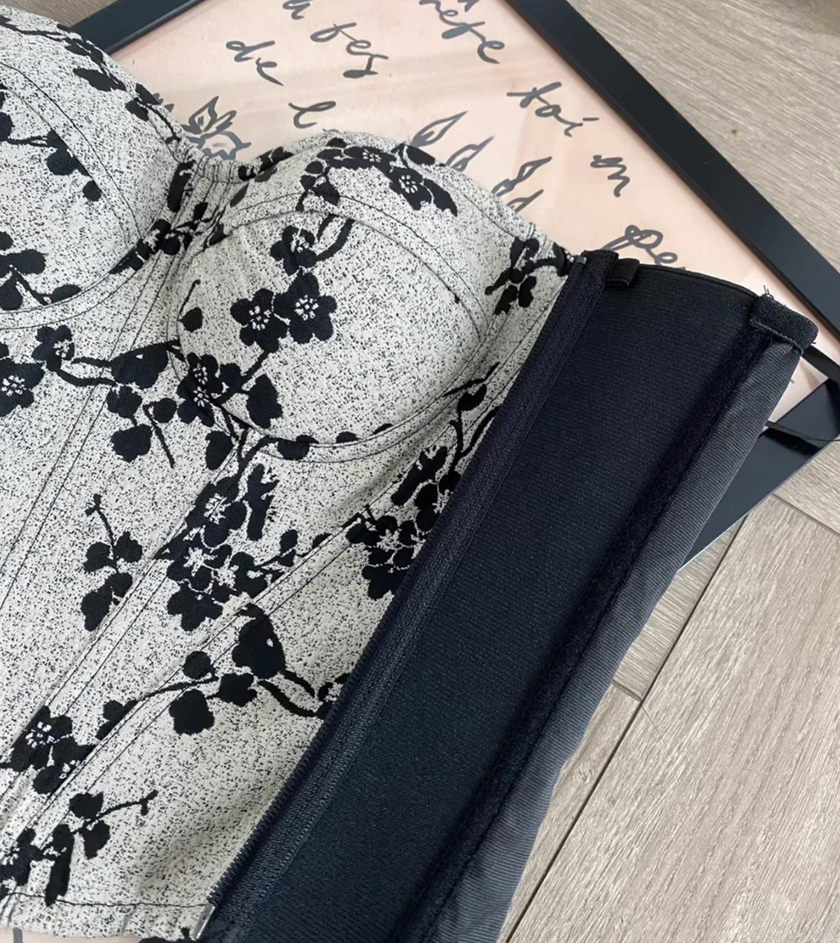 Ivy bustier corset featuring a black and white floral print, structured cups, and a black side zipper closure.