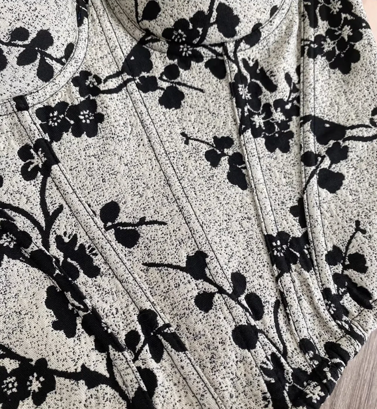 Ivy bustier corset featuring a black floral print on a textured white fabric with structured steel boning seams.