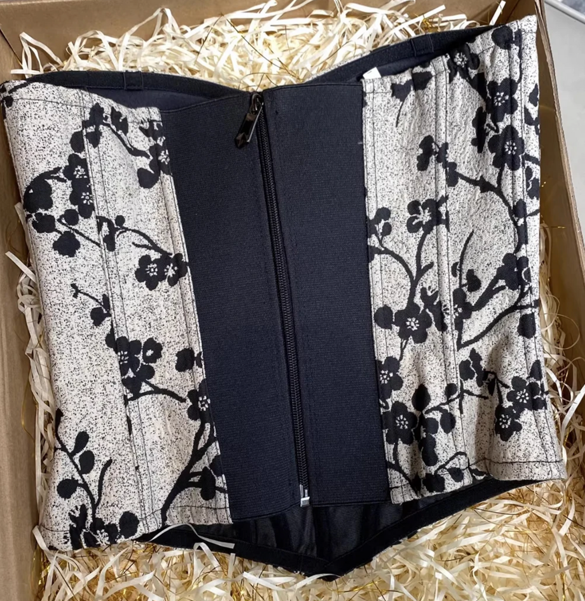 Ivy bustier corset featuring a black and white floral print, structured steel boning, and a center front zipper closure.