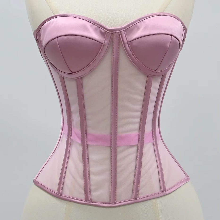 The Lilah pink satin and mesh corset bustier displayed on a cream-colored dress form mannequin against a neutral light gray background.