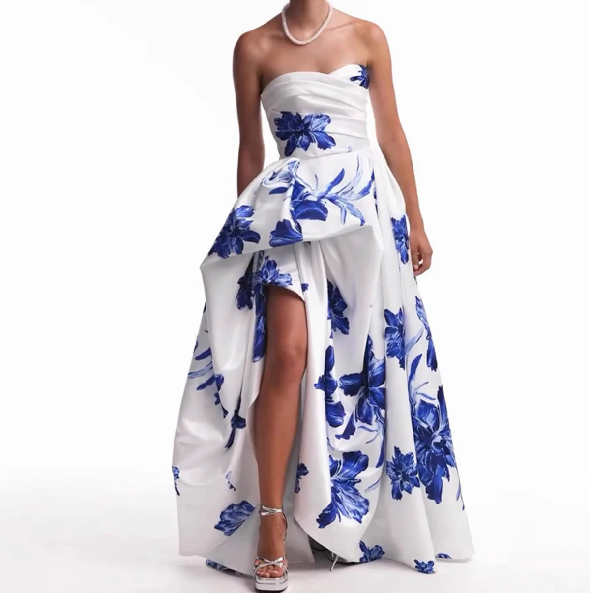 Woman wearing the Valjean Ave Maxi strapless white gown with blue floral patterns on a white background