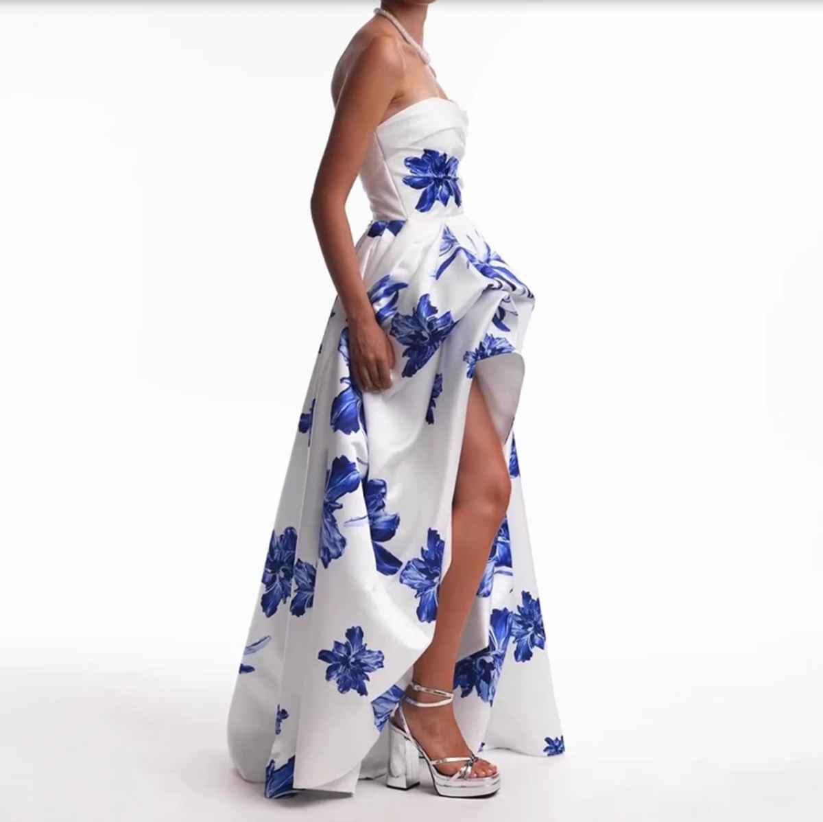 Woman wearing the Valjean Ave Maxi strapless white gown with blue floral patterns on a white background
