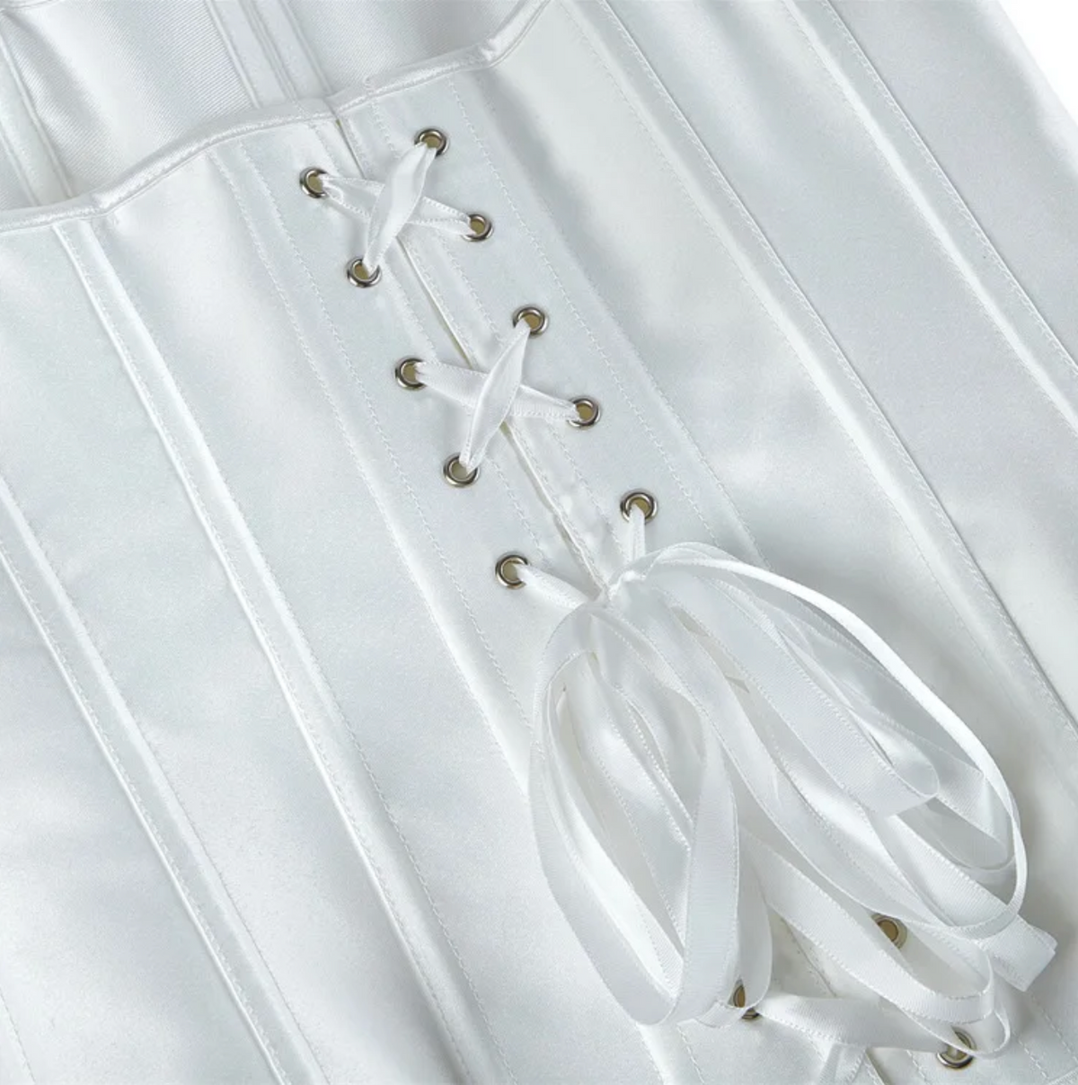 White satin overbust corset featuring structured boning and a decorative ribbon lace-up back with silver eyelets.