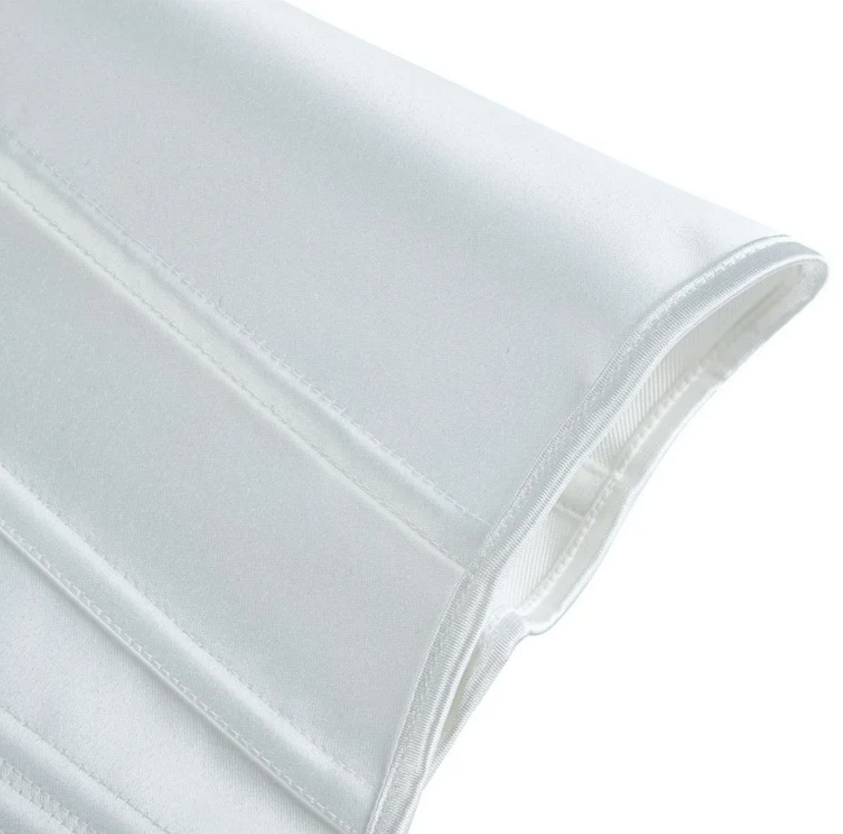 Close-up of a white satin Soli corset featuring structured boning and elegant stitching details.